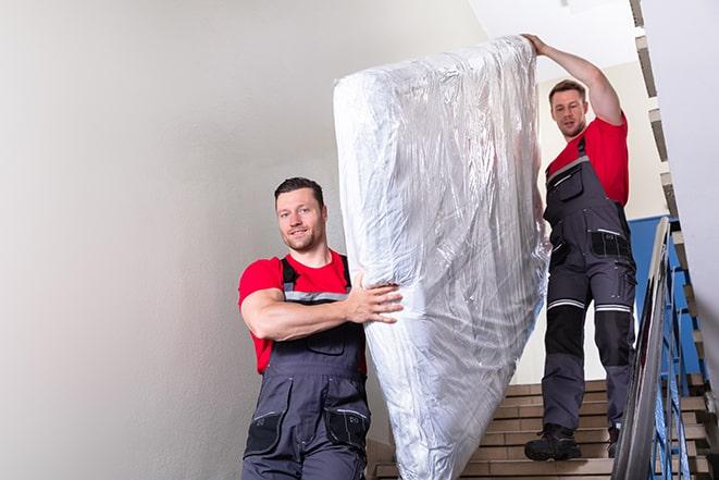 heavy-duty box spring being removed from a bedroom in Caruthers